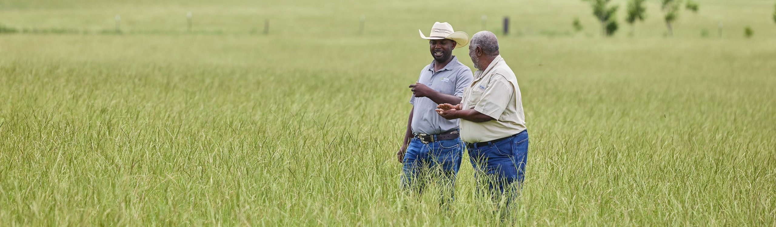 ADM rep and producer, Emmanuel Bankston walking in a field with Producer, Howard Hodge
